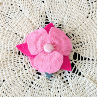 Pince fleur rose brodée avec des feuilles en feutrine de laine. Création artisanale par l'Atelier Jocha.