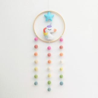 Suspension bambou ronde représentant une licorne multicolore dans les tons pastels, en feutrine de laine et des boules feutrées dégradés de couleurs. Création par l'Atelier Jocha.